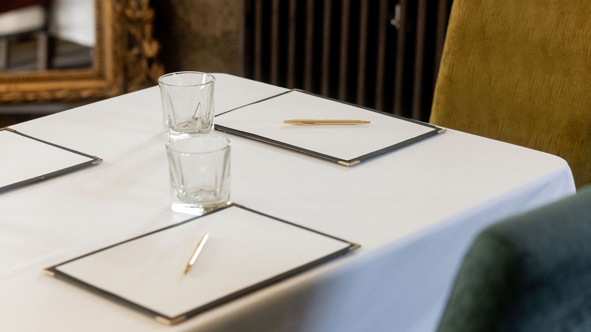 Close-up view of a meeting table with notepads, pens, and glasses.