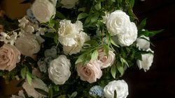 Close-up of a lush floral arrangement with white and blush roses and greenery