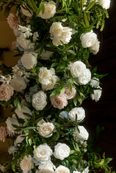 Close-up of a lush floral arrangement with white and blush roses and greenery