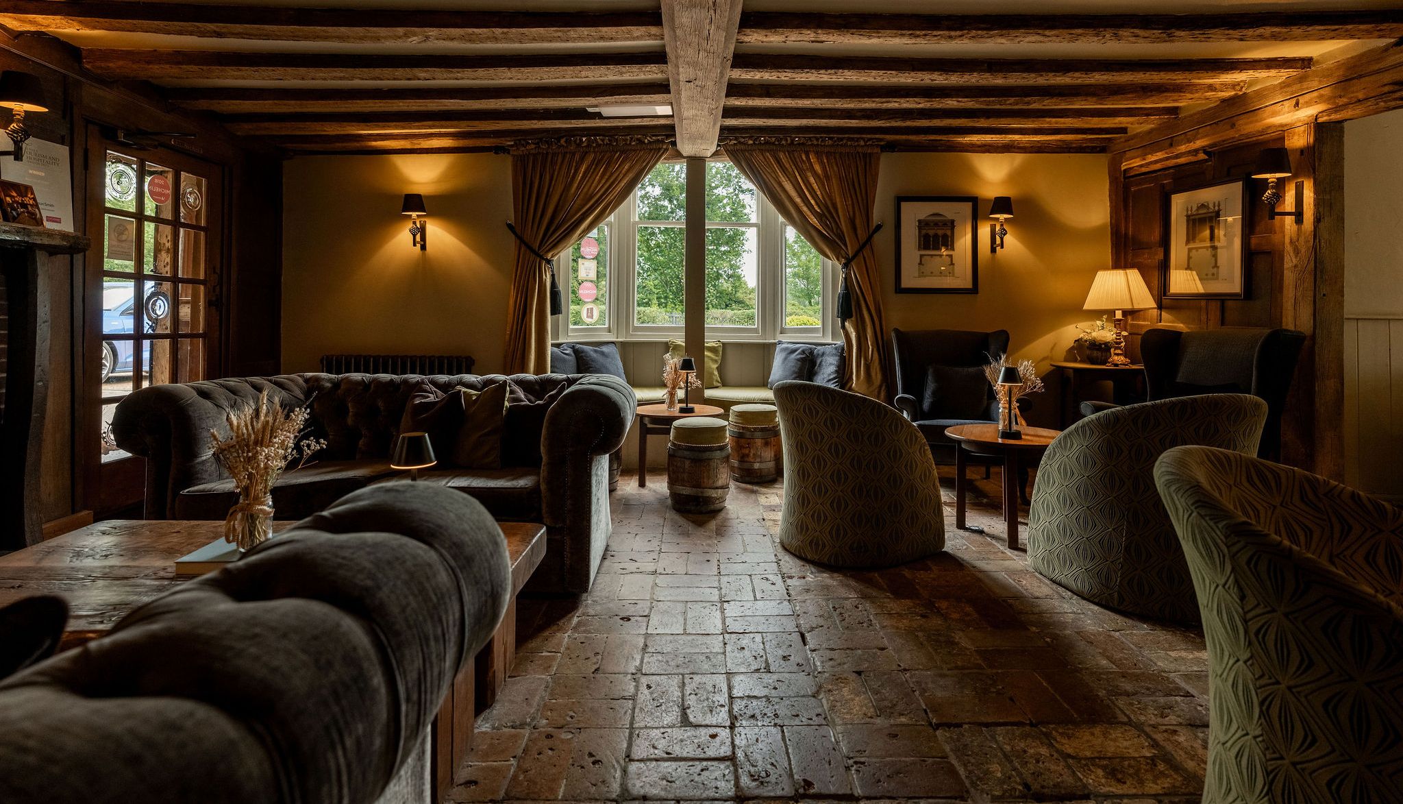 Cozy rustic lounge with exposed wooden beams, plush sofas, and warm lighting.
