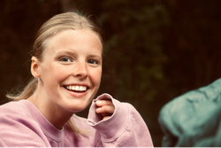 Smiling young person wearing a pink sweatshirt