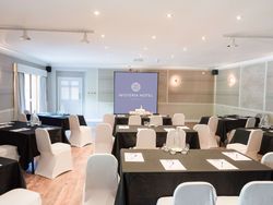 Conference room at Wisteria Hotel set up with tables and chairs for a meeting