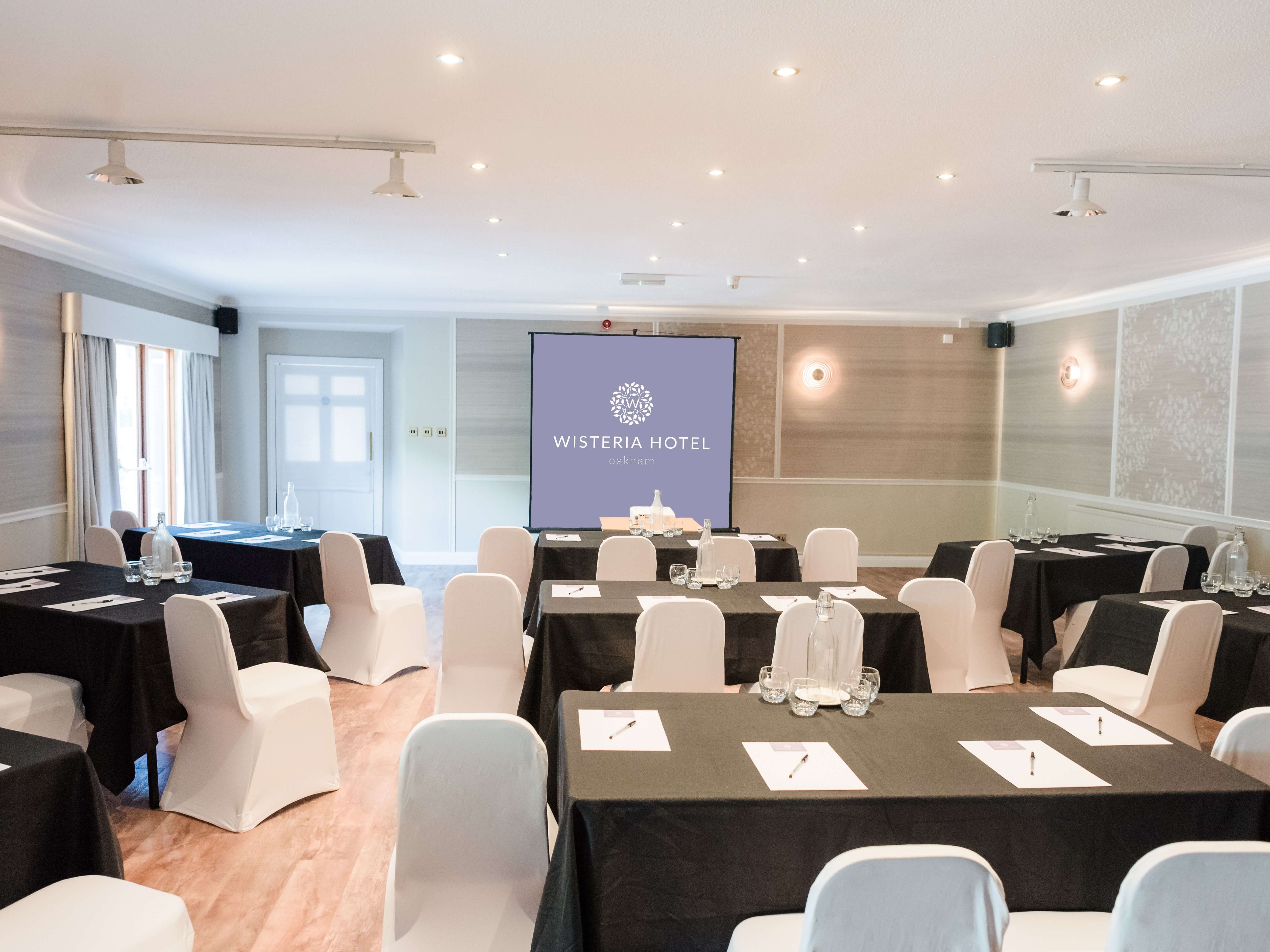 Conference room at Wisteria Hotel set up with tables and chairs for a meeting