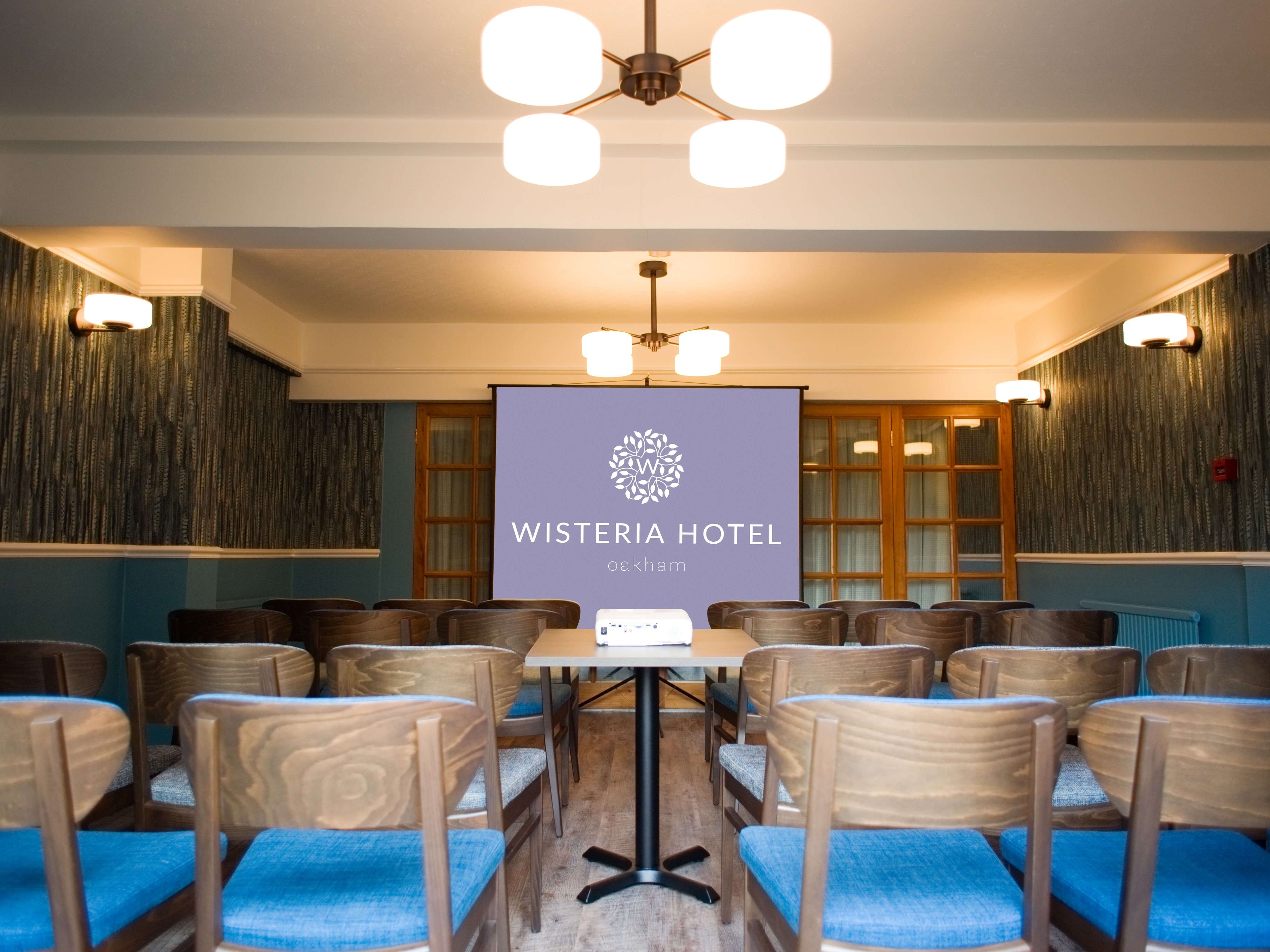 Conference room at Wisteria Hotel Oakham with chairs arranged facing a projection screen.