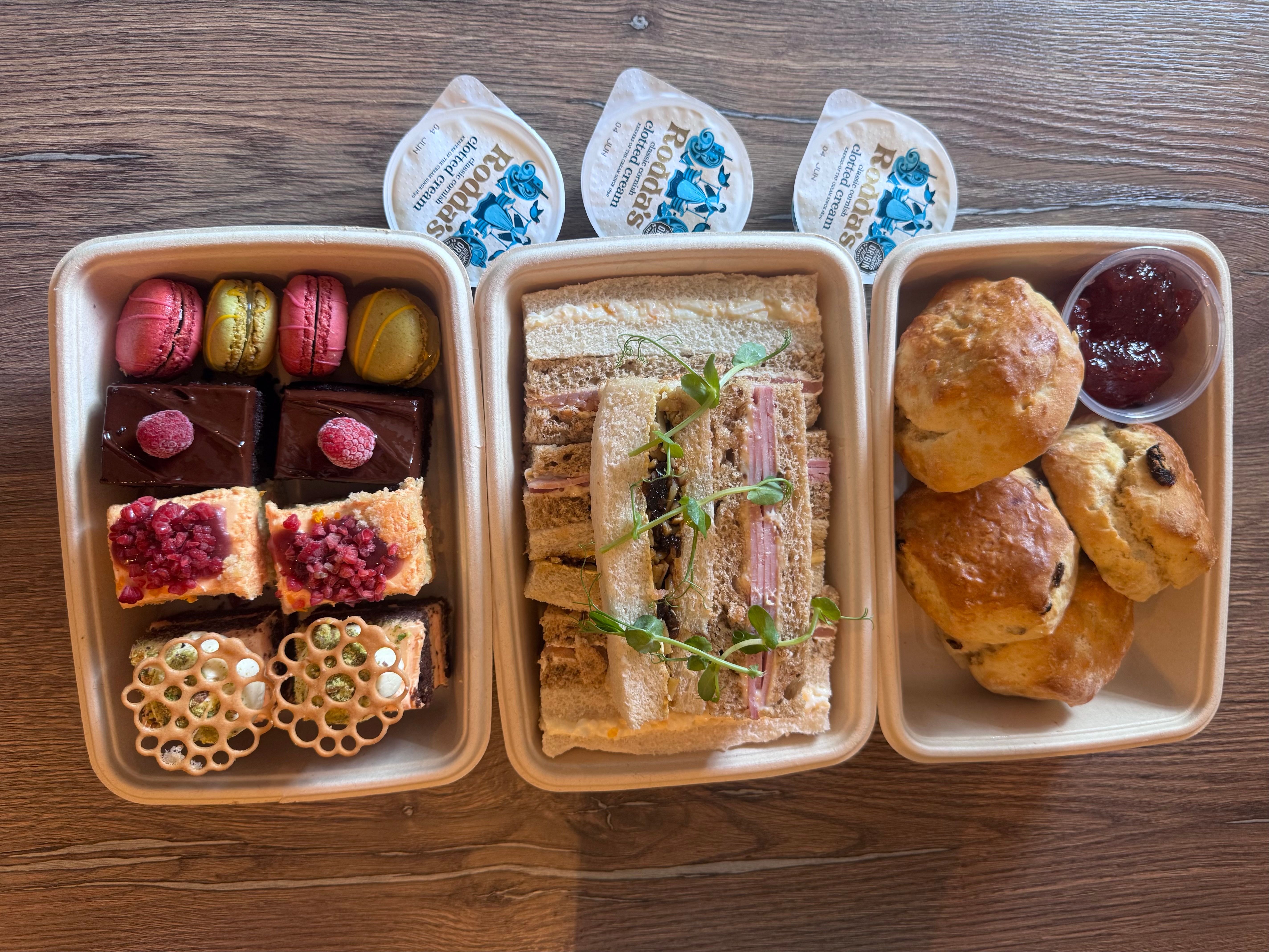 Afternoon tea set with assorted pastries, finger sandwiches, scones with cream and jam