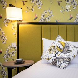 Bedroom showing beautiful head board in mustard yellow with matching wallpaper