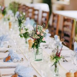 Vase of flowers on a table set out for a wedding