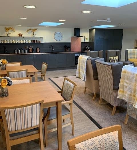 Care home lounge with dark grey kitchen