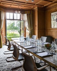 meeting room with wood panels and doors opening out onto the gardens