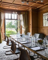 meeting room with wood panels and doors opening out onto the gardens