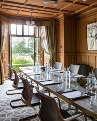 meeting room with wood panels and doors opening out onto the gardens