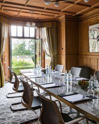meeting room with wood panels and doors opening out onto the gardens