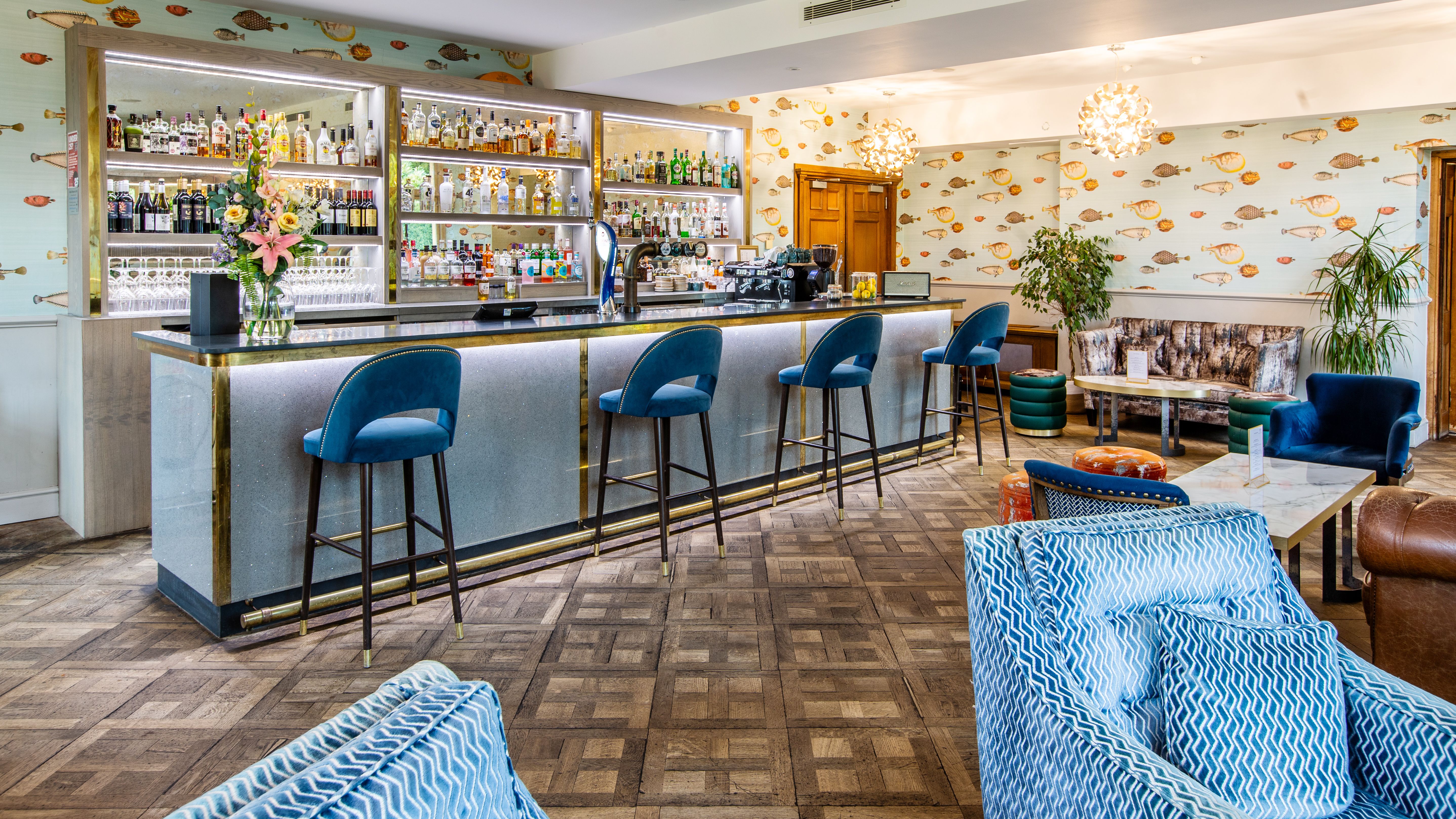 View of bar , with blue velvet chairs and led lights surrounding bar area