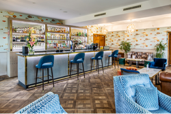 View of bar , with blue velvet chairs and led lights surrounding bar area