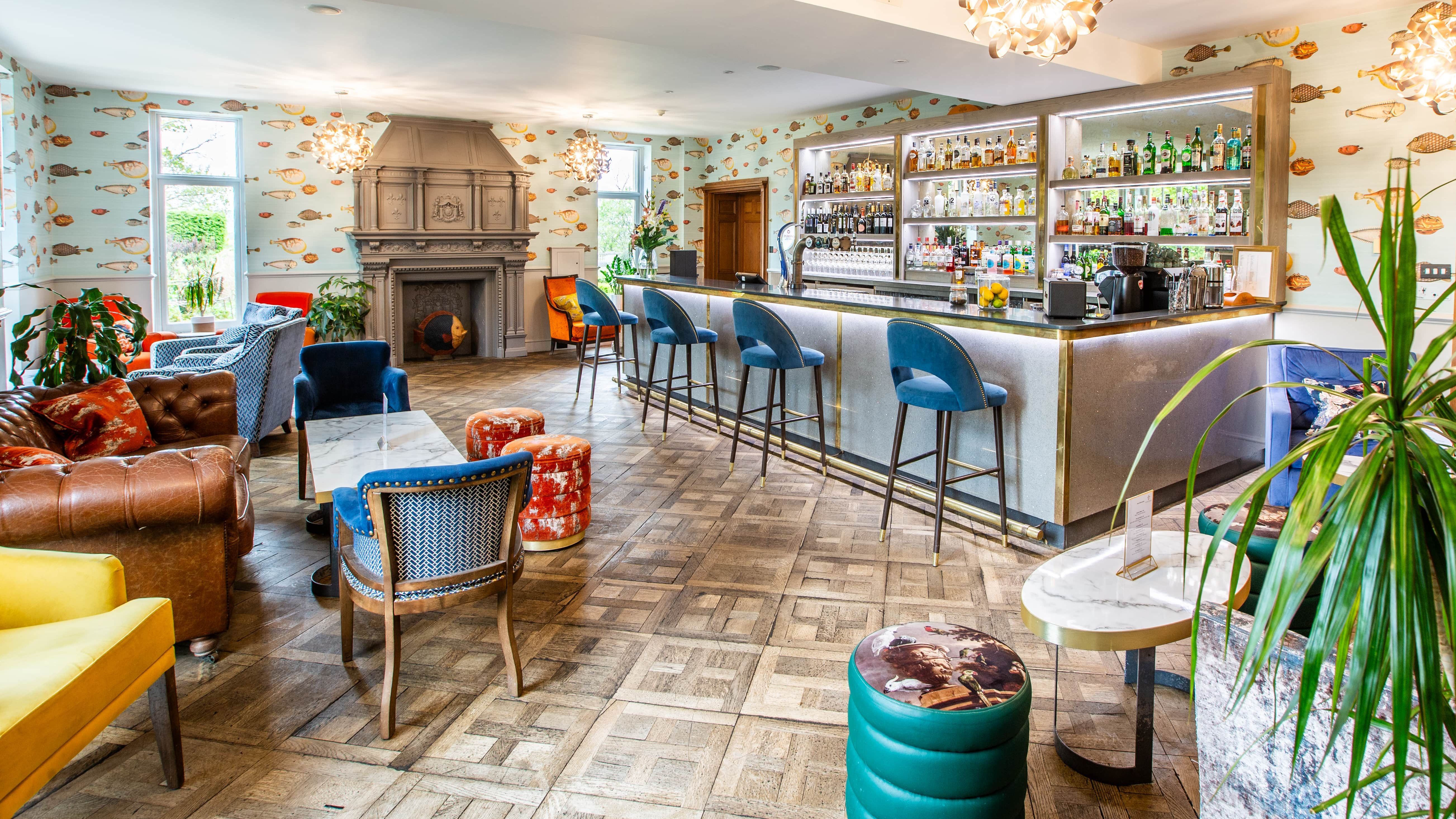 A view of the bar area and surroundings, lots of multicoloured chairs around a codffee table