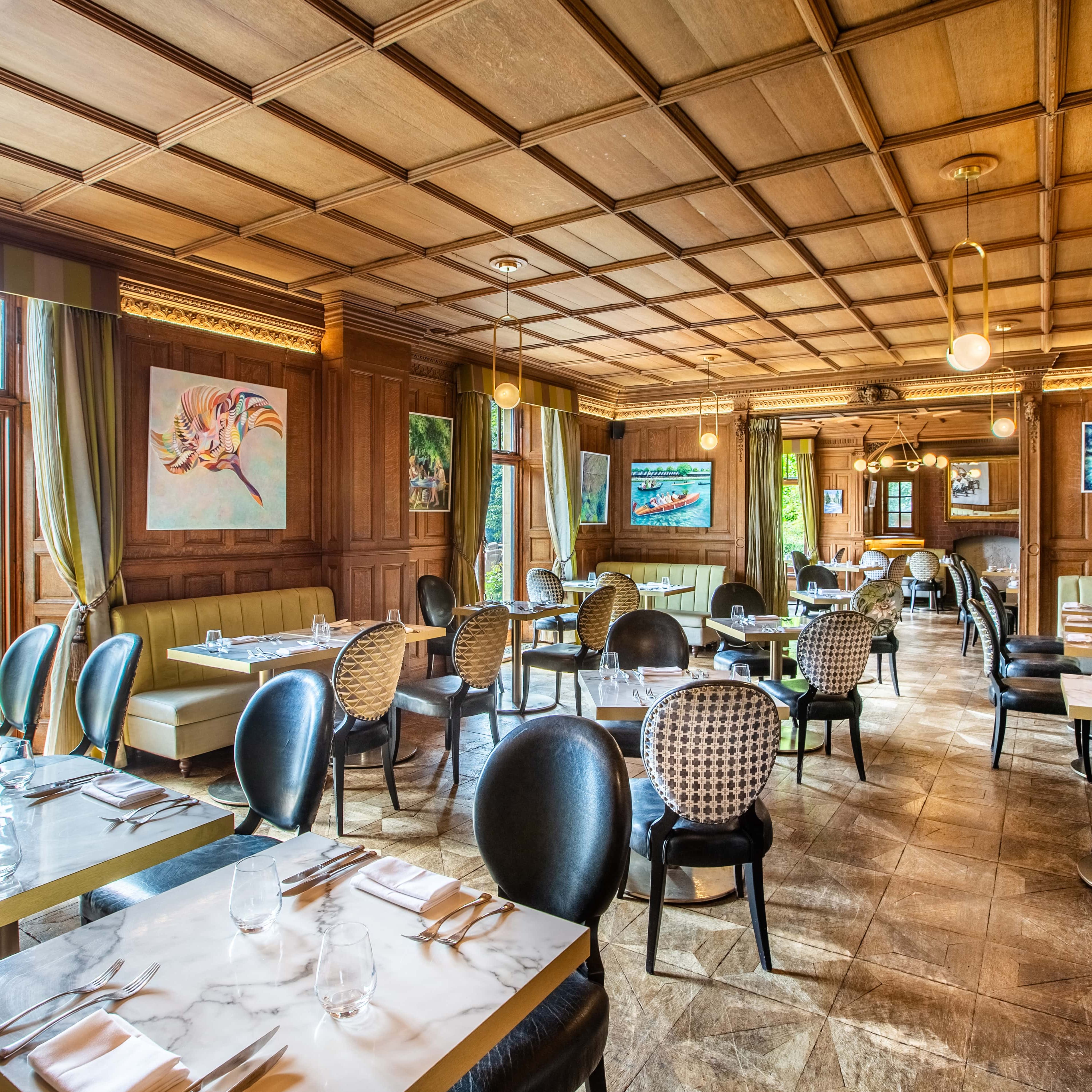 View of dining area, with lots of tables and chairs in a wooden room with big windows