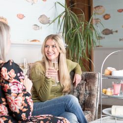 Two Ladies talking over an Afternoon Tea holding a glass of Prosecco