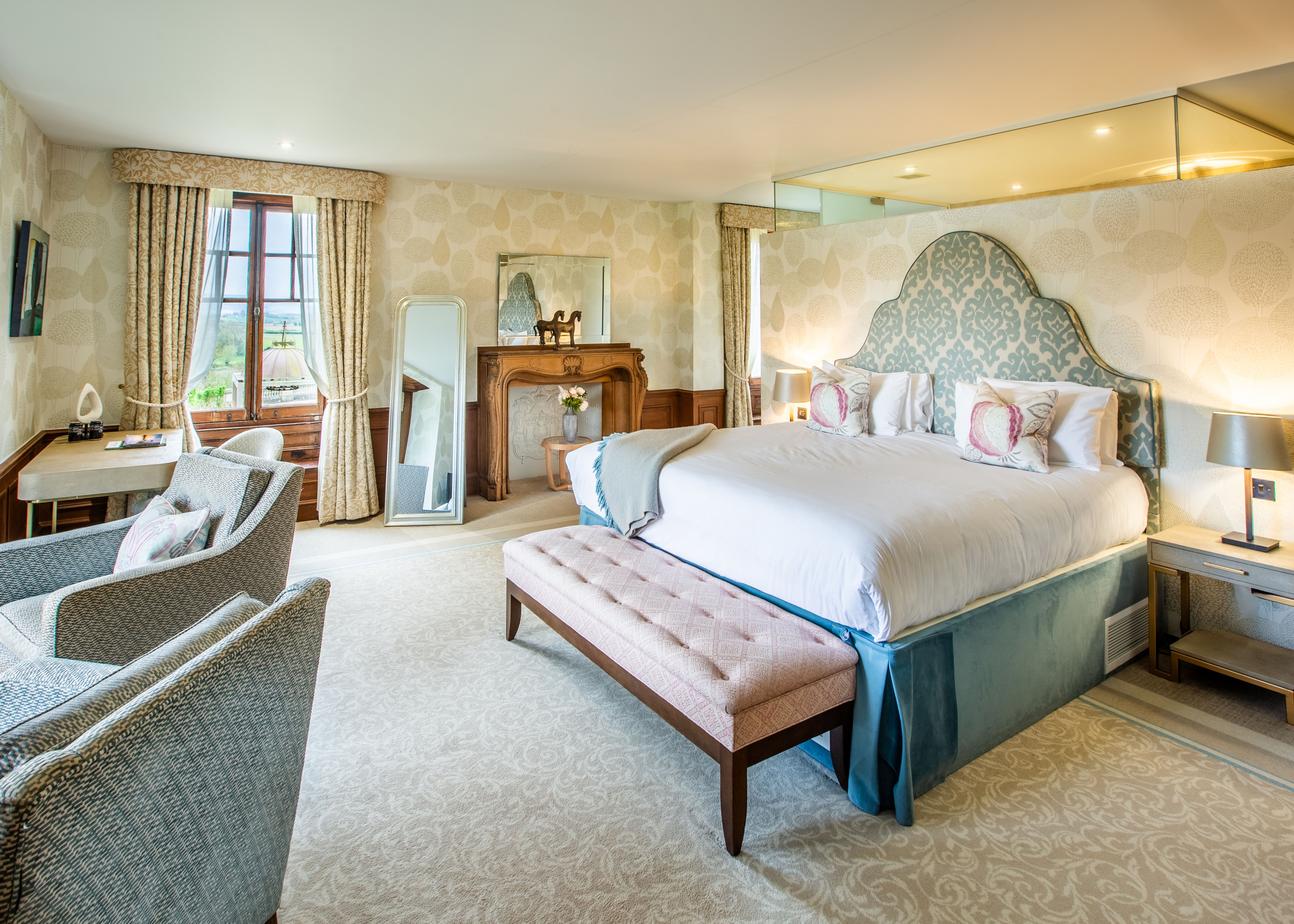 Spacious Bedroom with blue theme sofa chairs and bedding