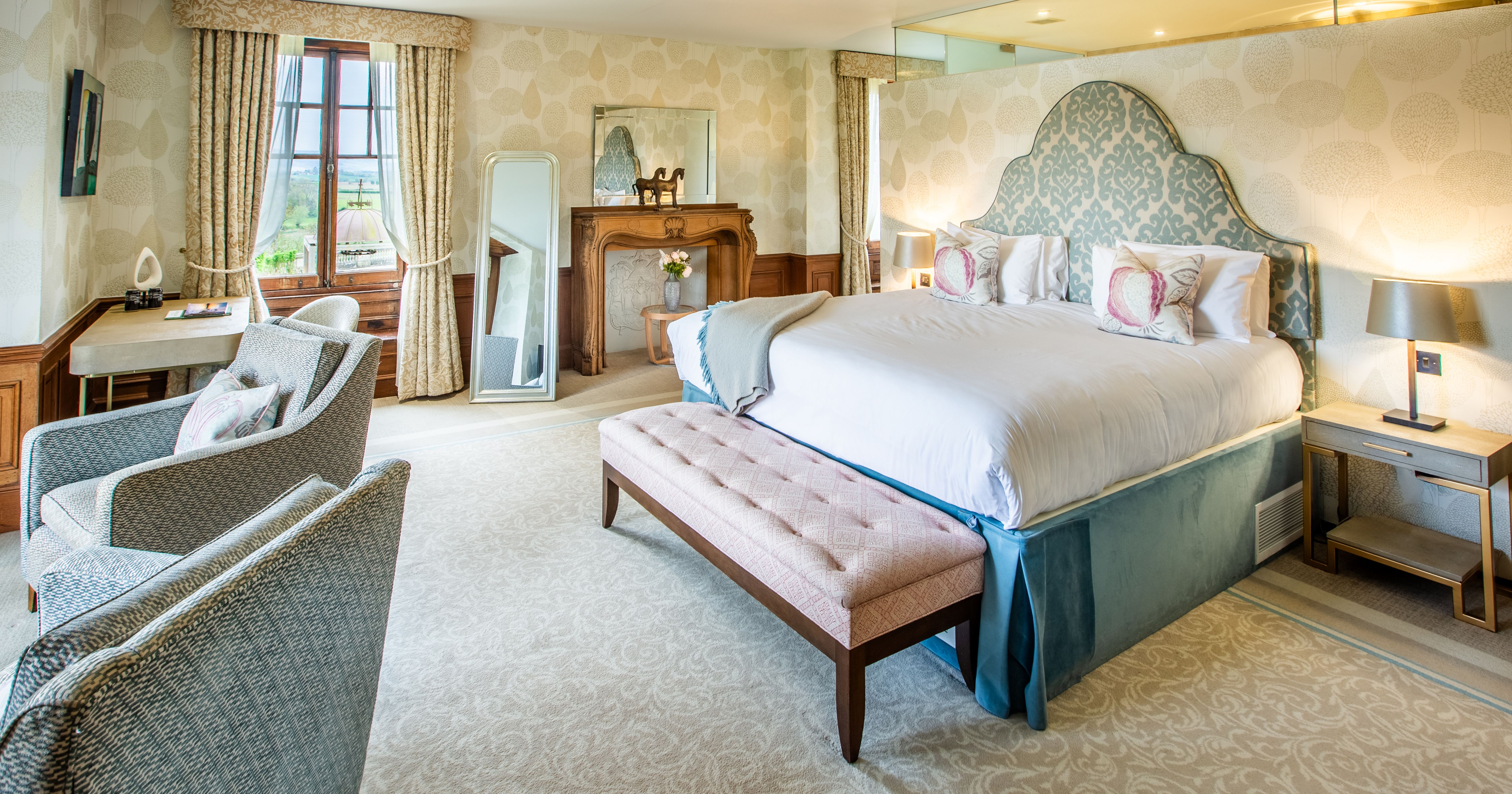 Spacious Bedroom with blue theme sofa chairs and bedding