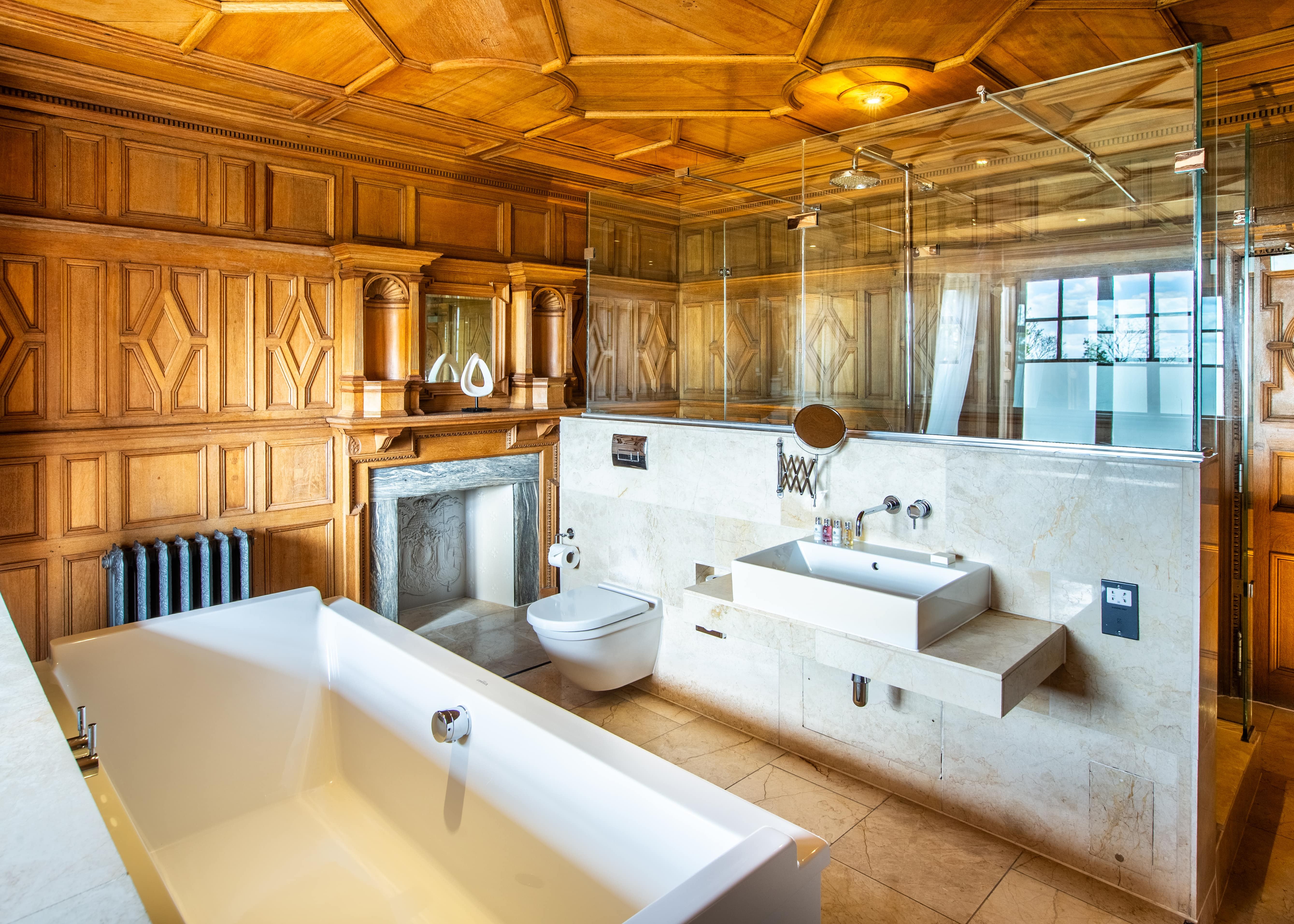 Walk in shower and bath in wood panelled bathroom