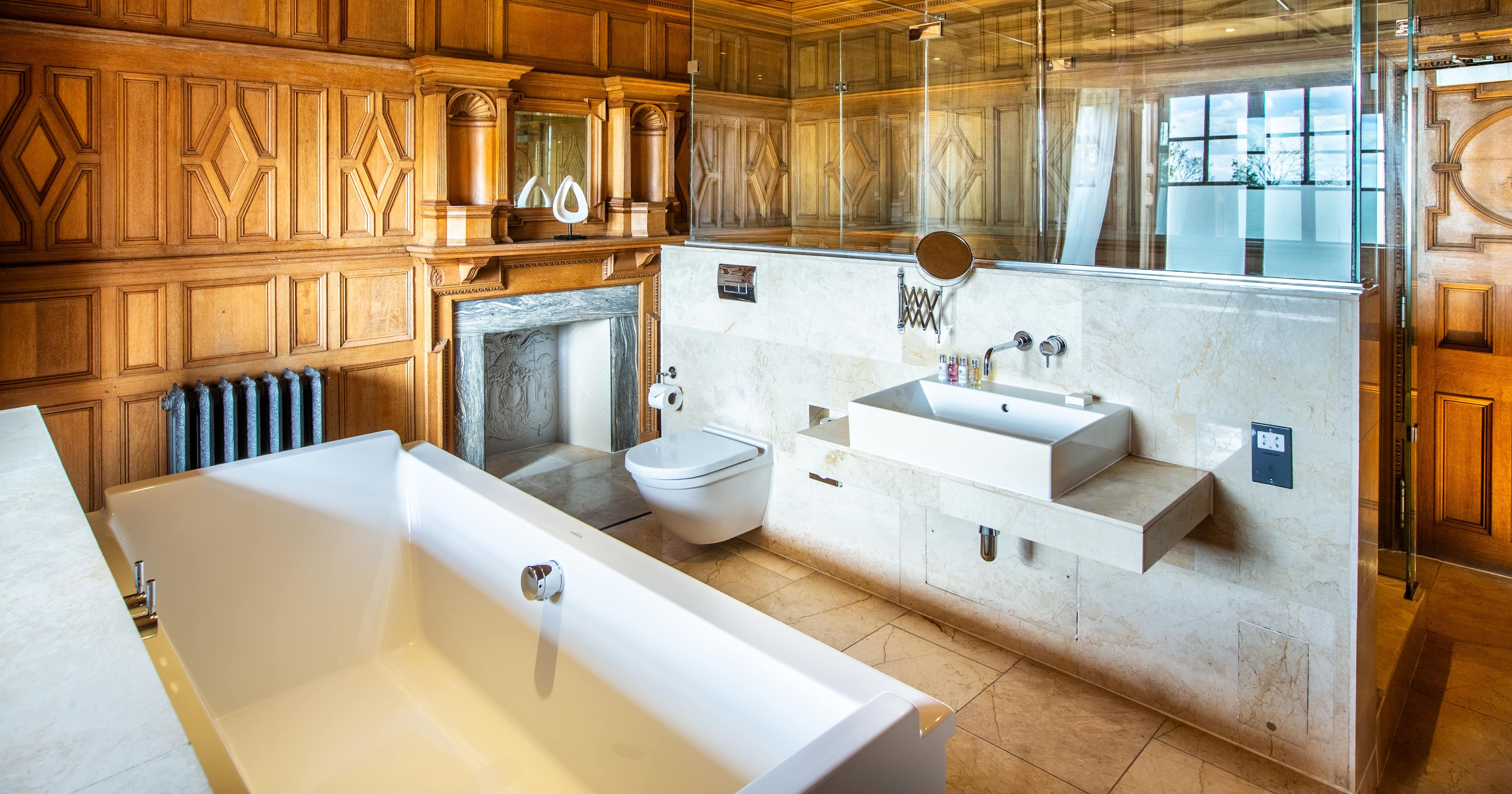 Walk in shower and bath in wood panelled bathroom