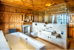 Walk in shower and bath in wood panelled bathroom