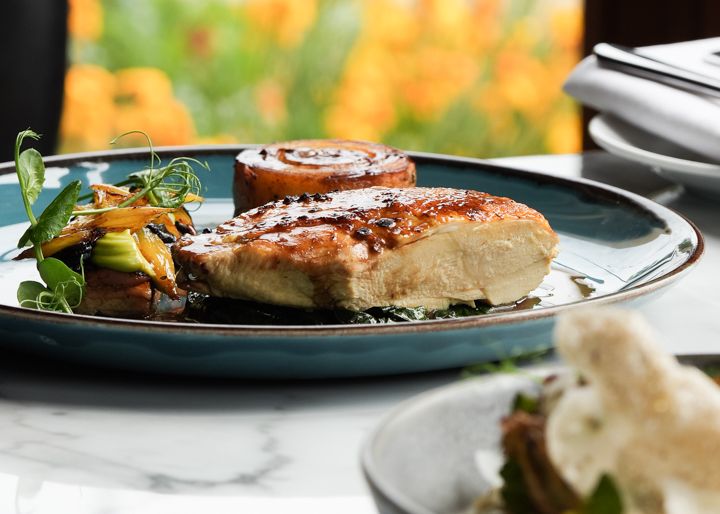 Meal on a plate with large windows with orange flowers