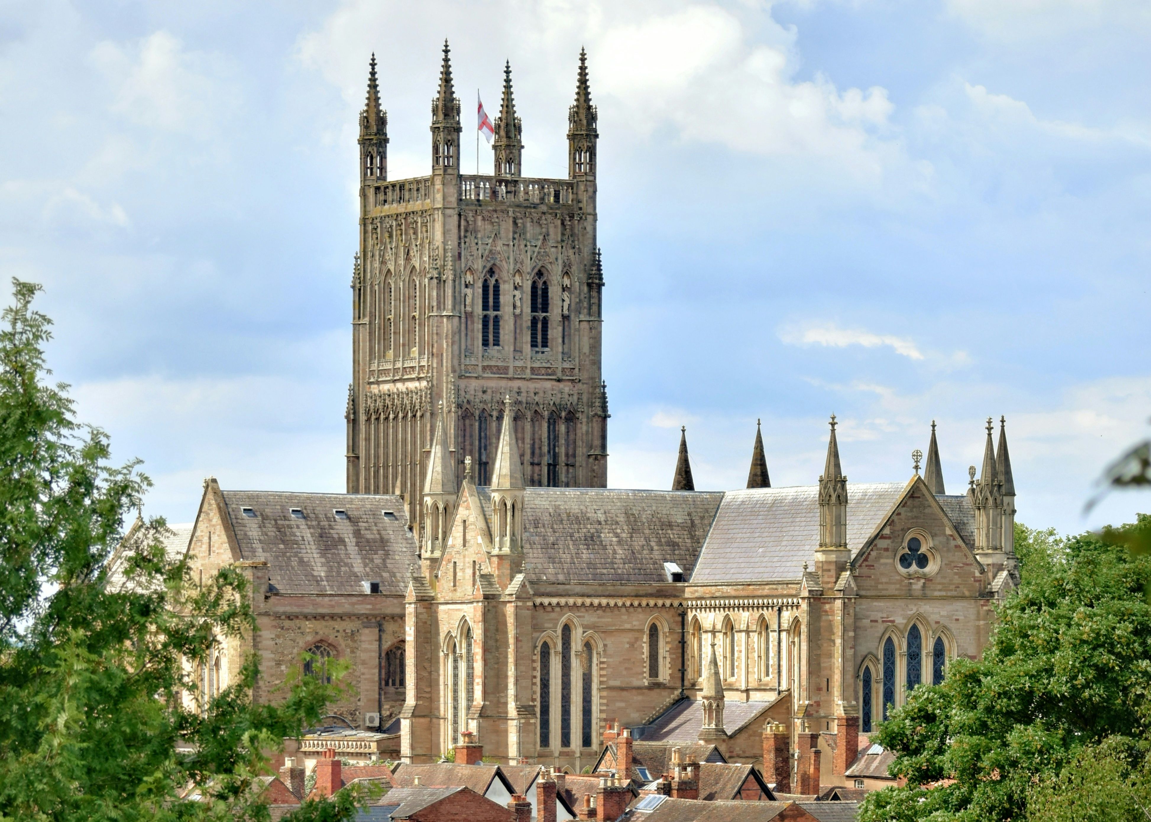 adam-joView of Worcester Cathedral towering above the city’s rooftops, framed by trees on a summer daynes-gKOAyHyxT2Q-unsplash