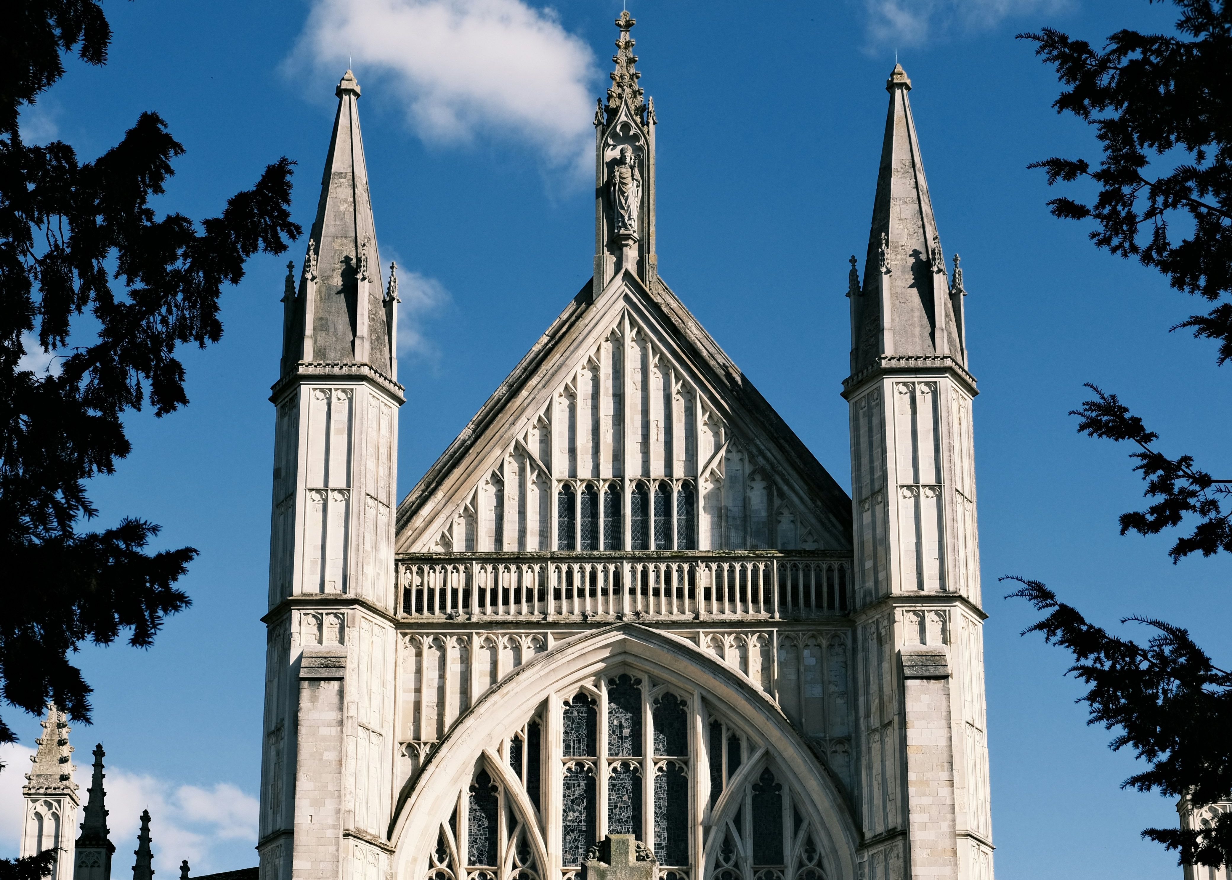 Winchester Cathedral with its tall gothic towers and stained glass windows on a sunny day