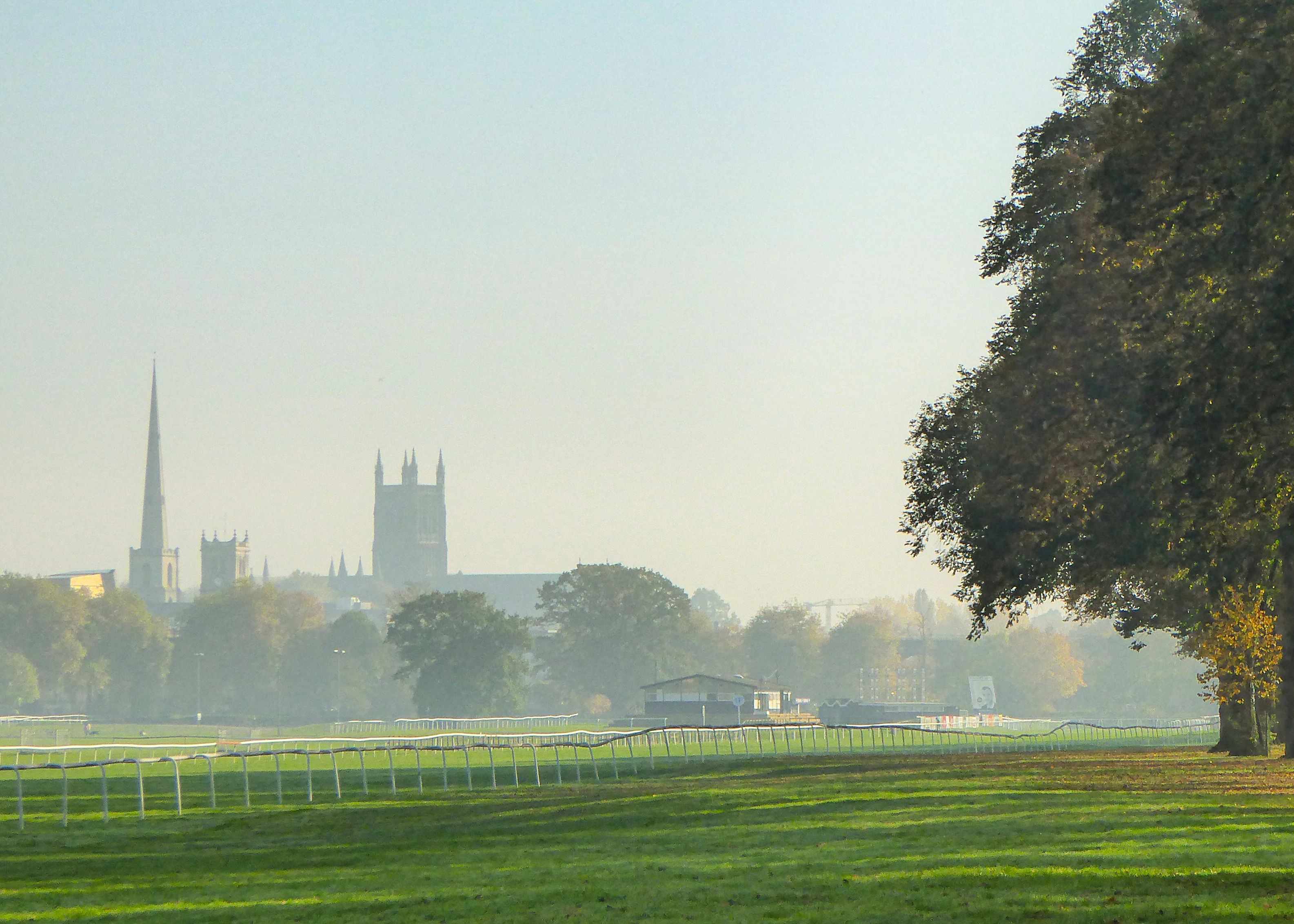 Worcester Racecourse on a misty morning with cathedral spires in the distance and trees casting long shadows