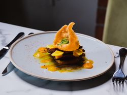 Food on plate with pork scratching on top