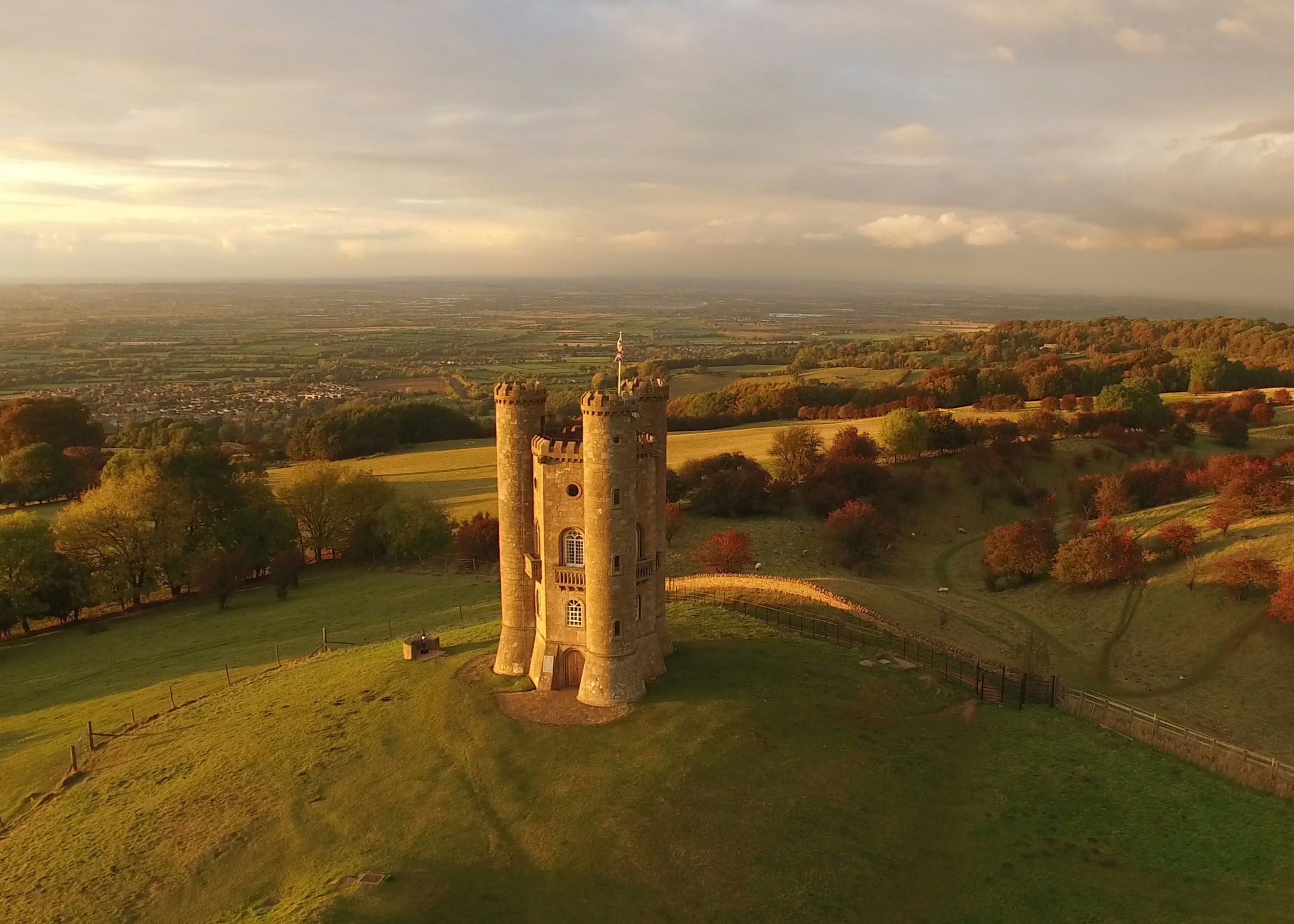 Aerial view of Broadway Tower on a hilltop at sunset with views over the Cotswold countryside