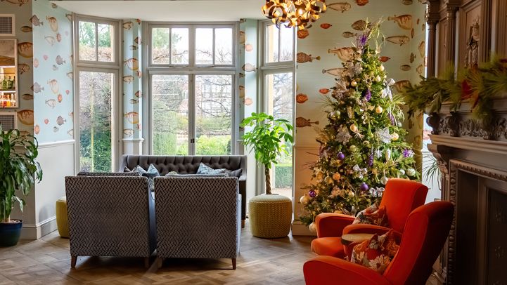 Cozy living room with modern lighting, Christmas tree, and comfortable seating