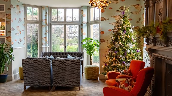 Cozy living room with modern lighting, Christmas tree, and comfortable seating