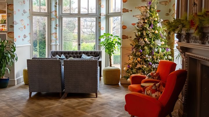 Cozy living room with modern lighting, Christmas tree, and comfortable seating