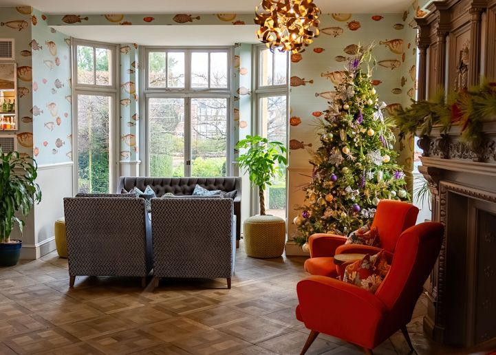 Cozy living room with modern lighting, Christmas tree, and comfortable seating