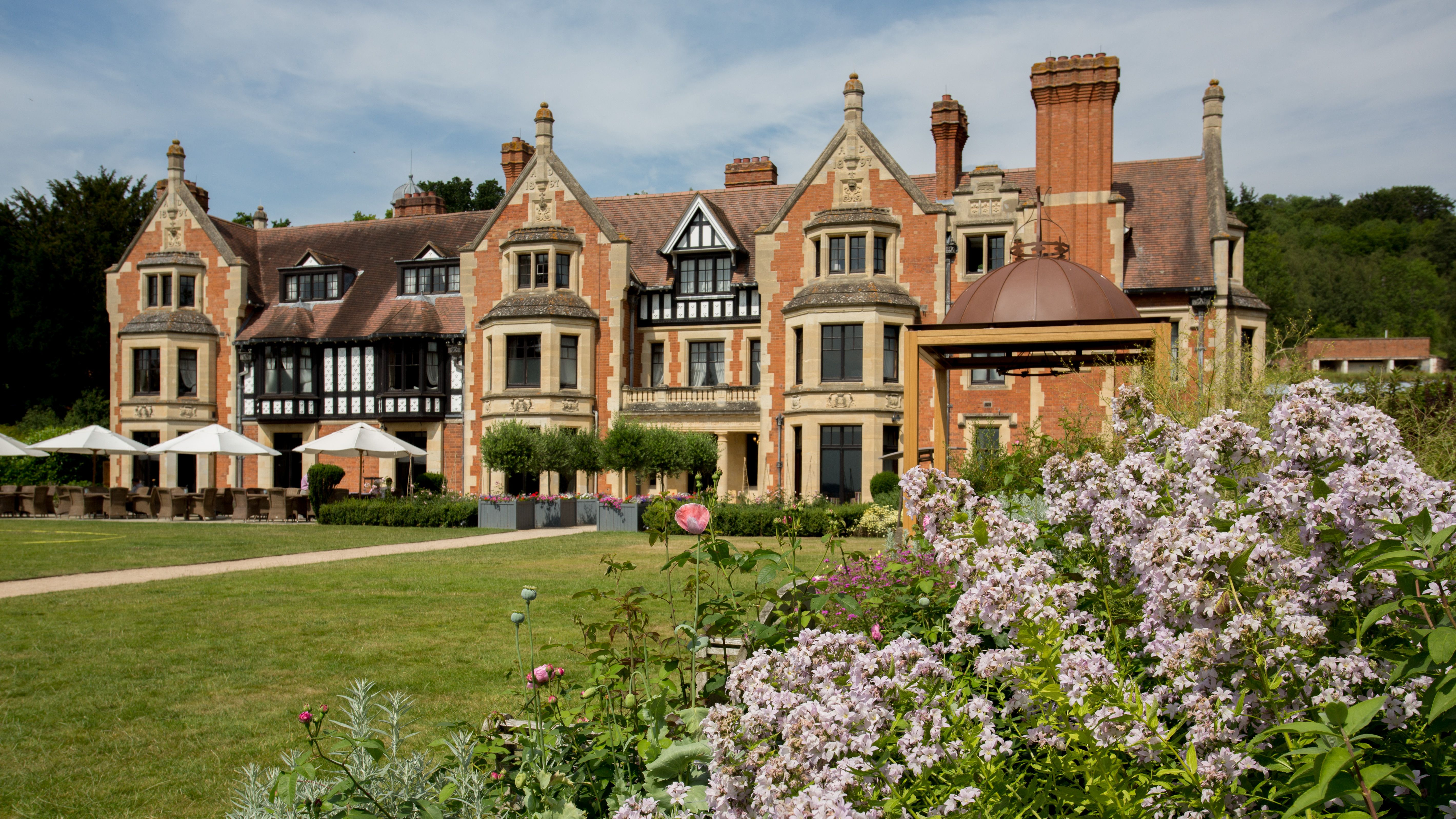 Elegant historic hotel exterior with manicured gardens and blooming flowers