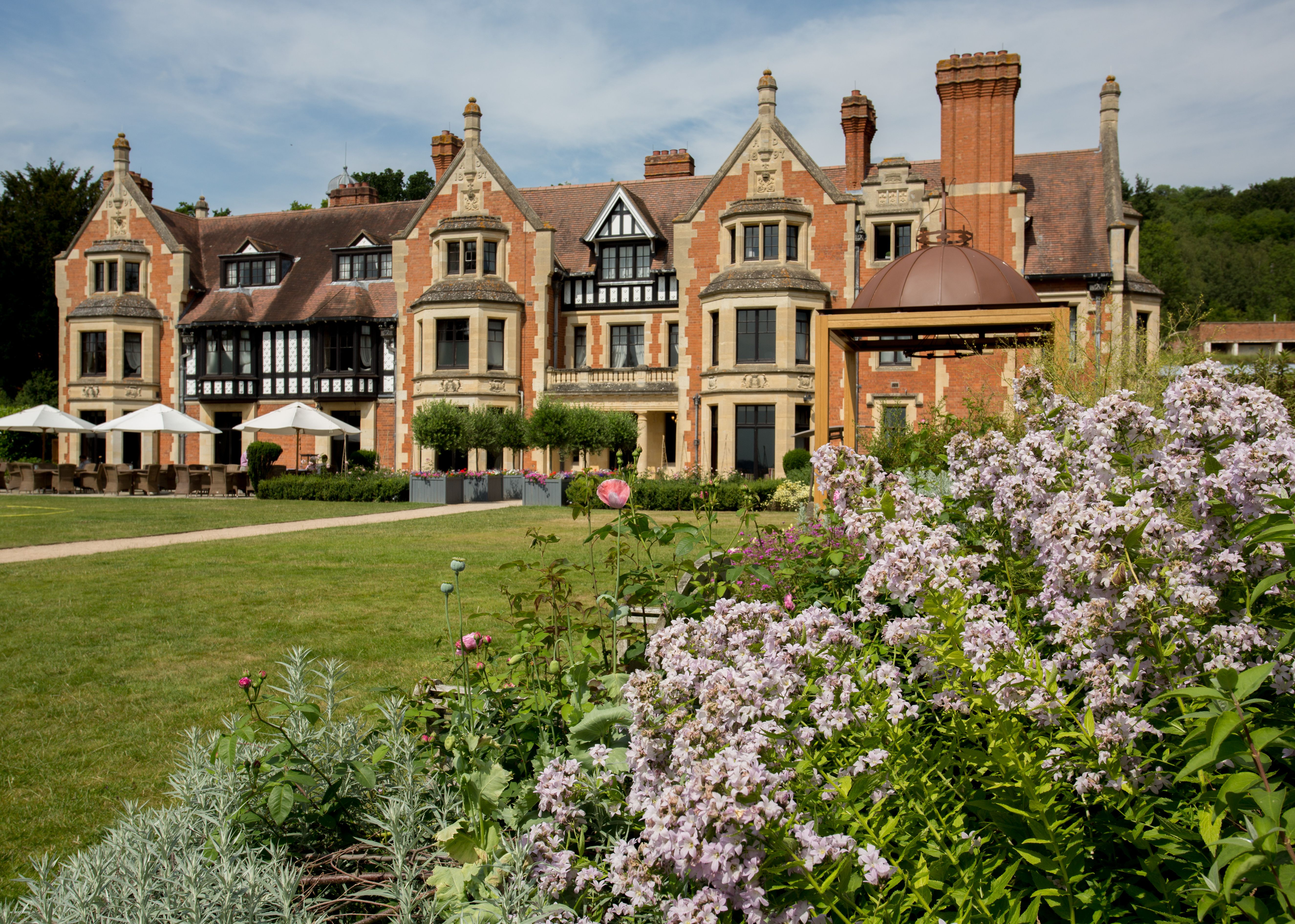 Elegant historic hotel exterior with manicured gardens and blooming flowers