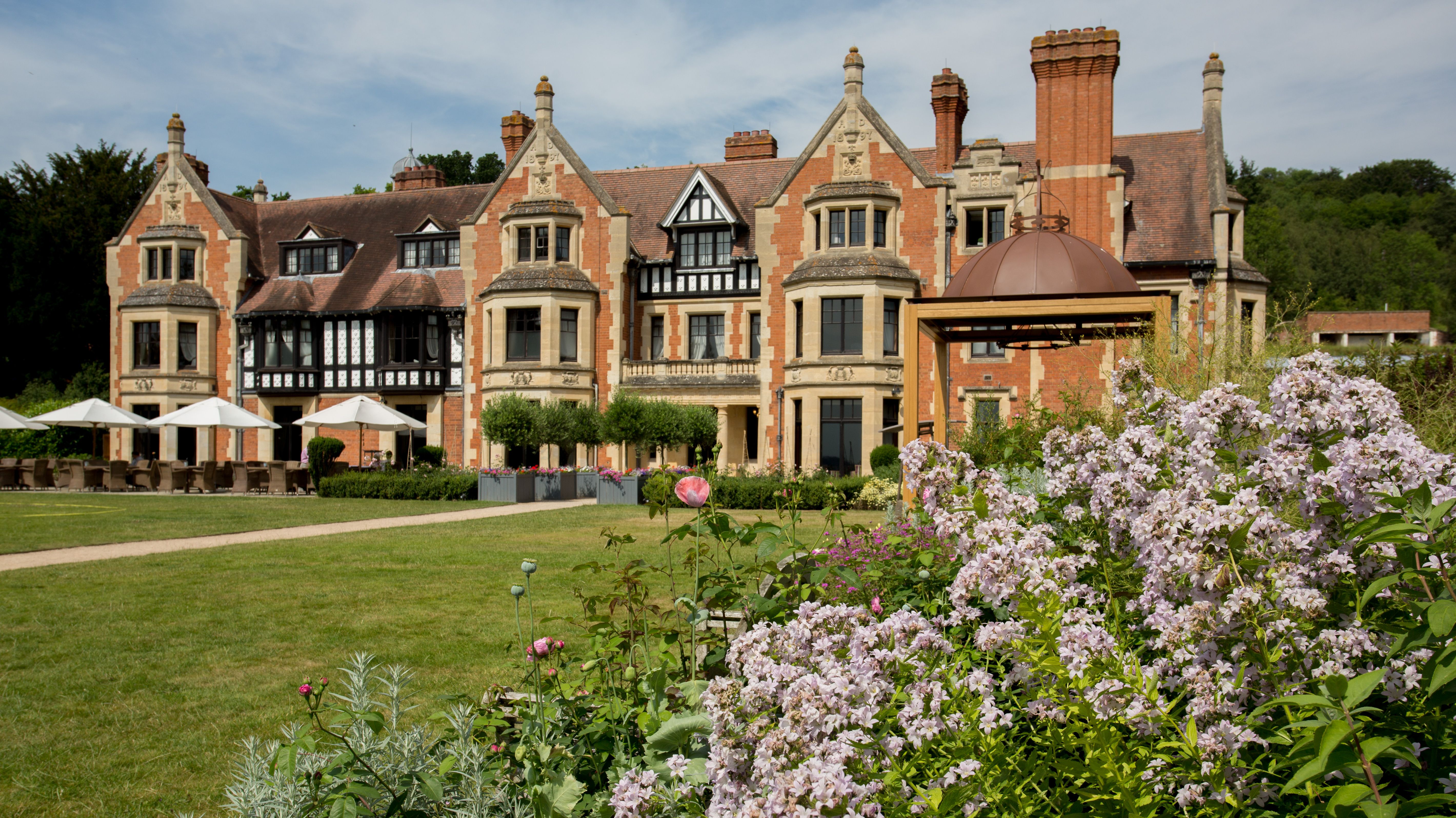 Elegant historic hotel exterior with manicured gardens and blooming flowers