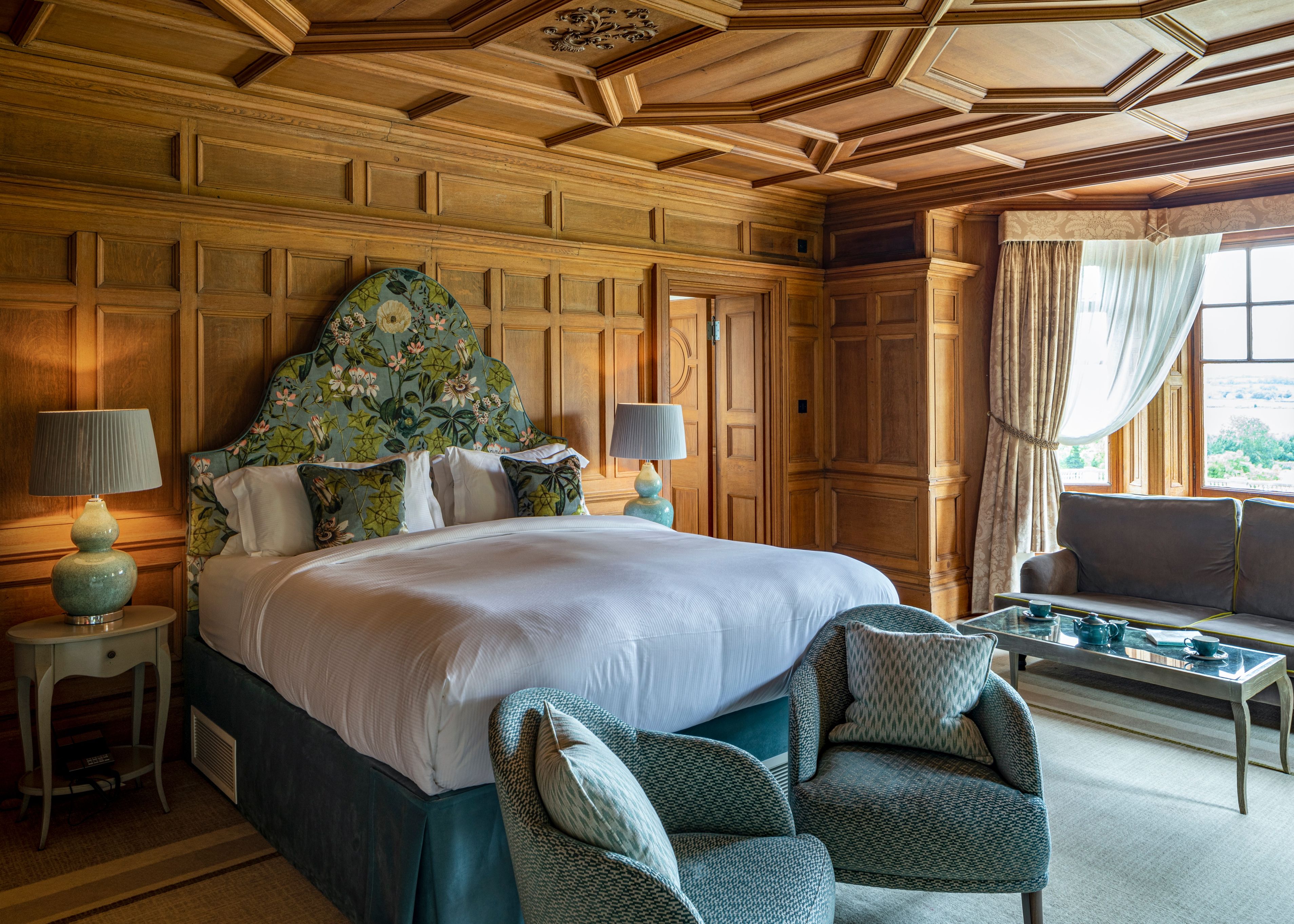 Balcony Junior Suite with wood panelling and large bed with beautiful headboard