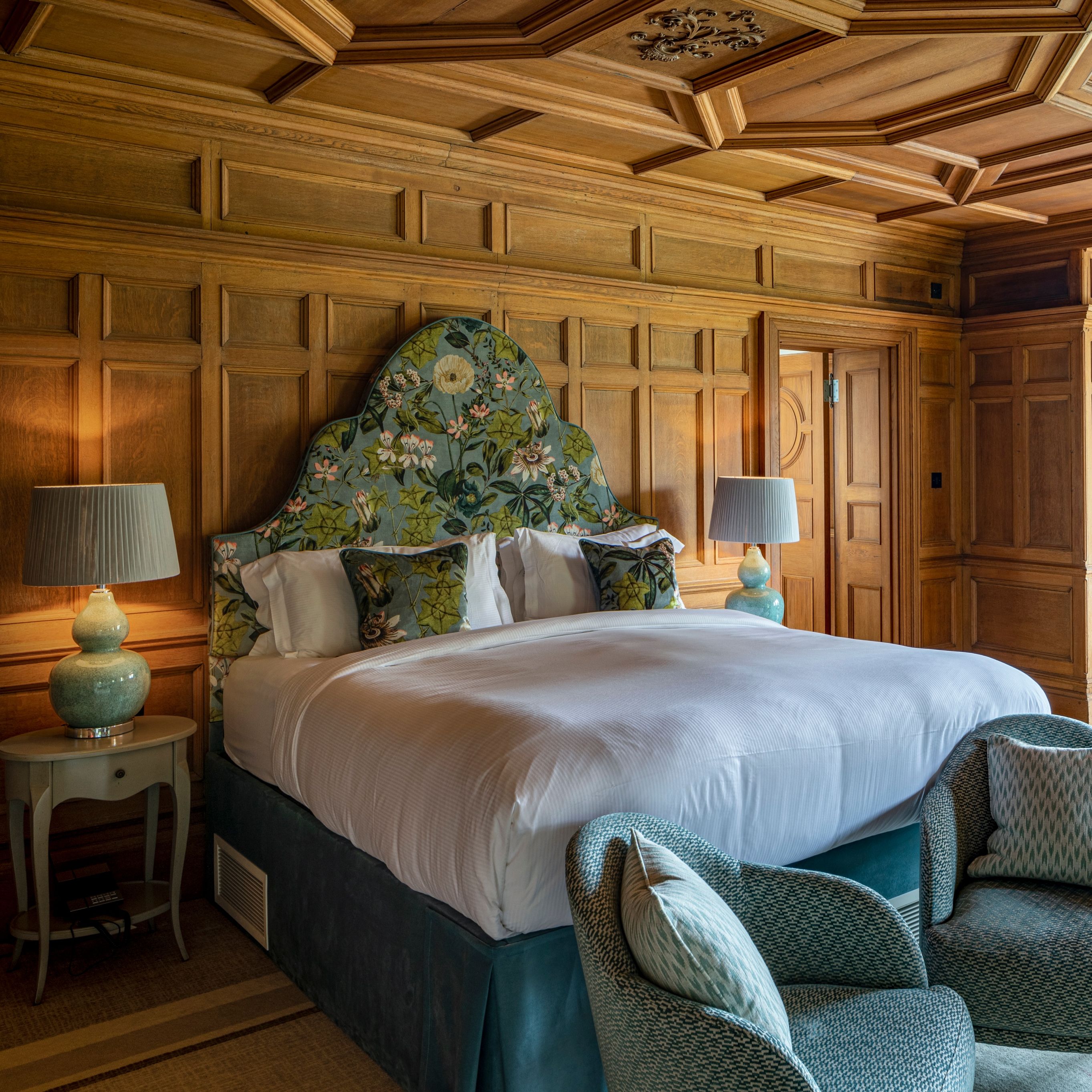 Balcony Junior Suite with wood panelling and large bed with beautiful headboard