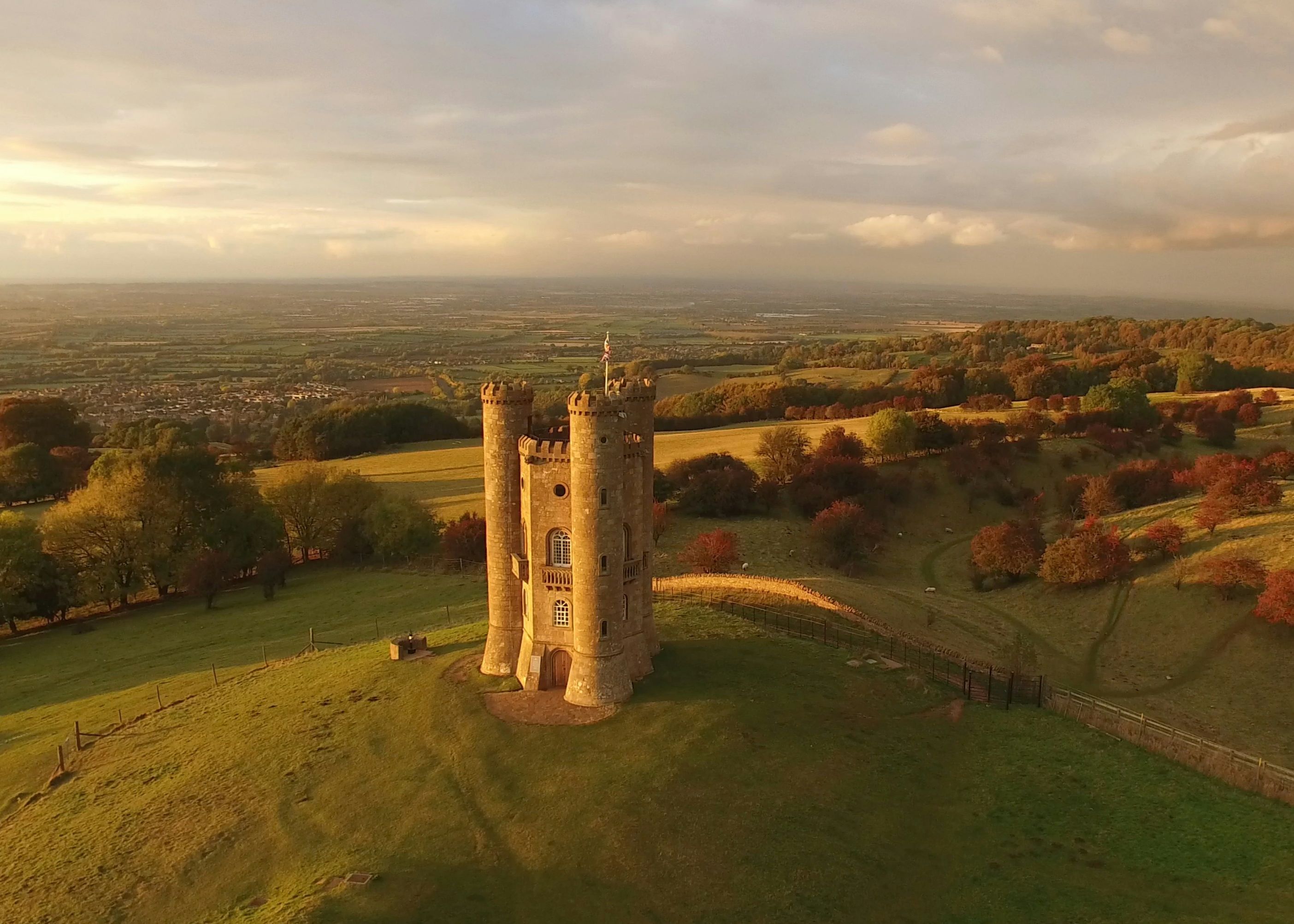 Aerial view of a stone tower on a hill surrounded by countryside