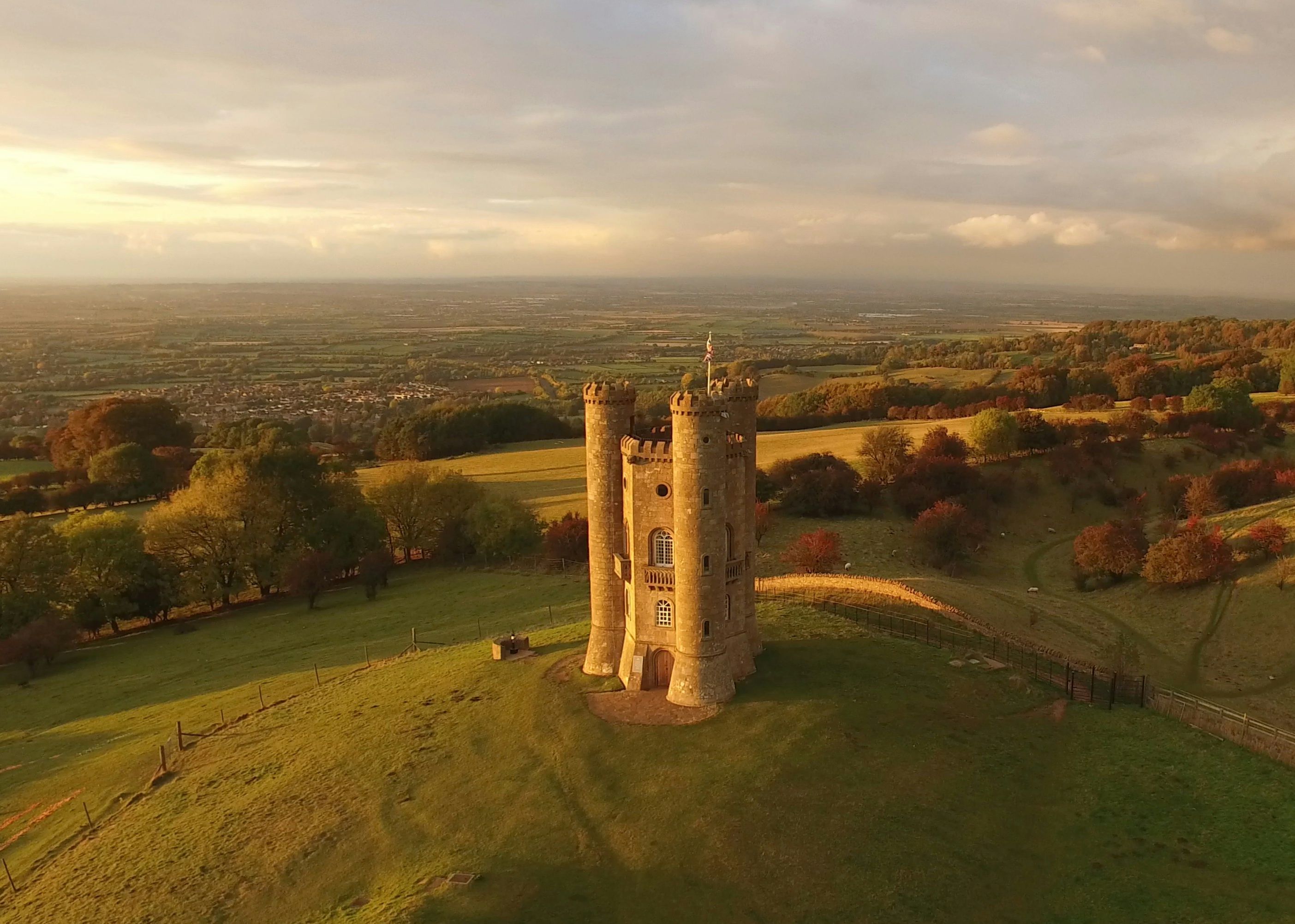 Aerial view of a stone tower on a hill surrounded by countryside