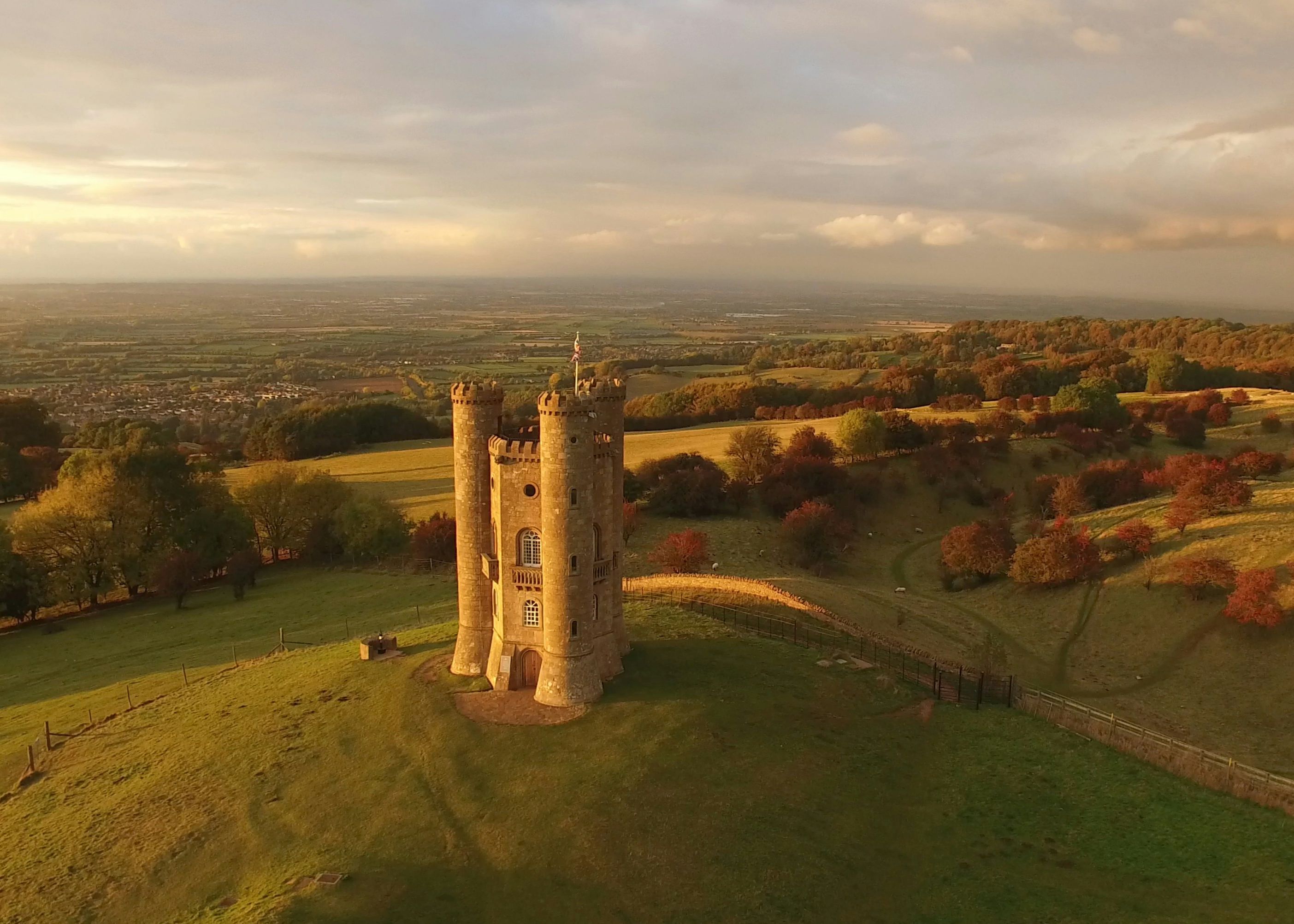 Aerial view of a stone tower on a hill surrounded by countryside