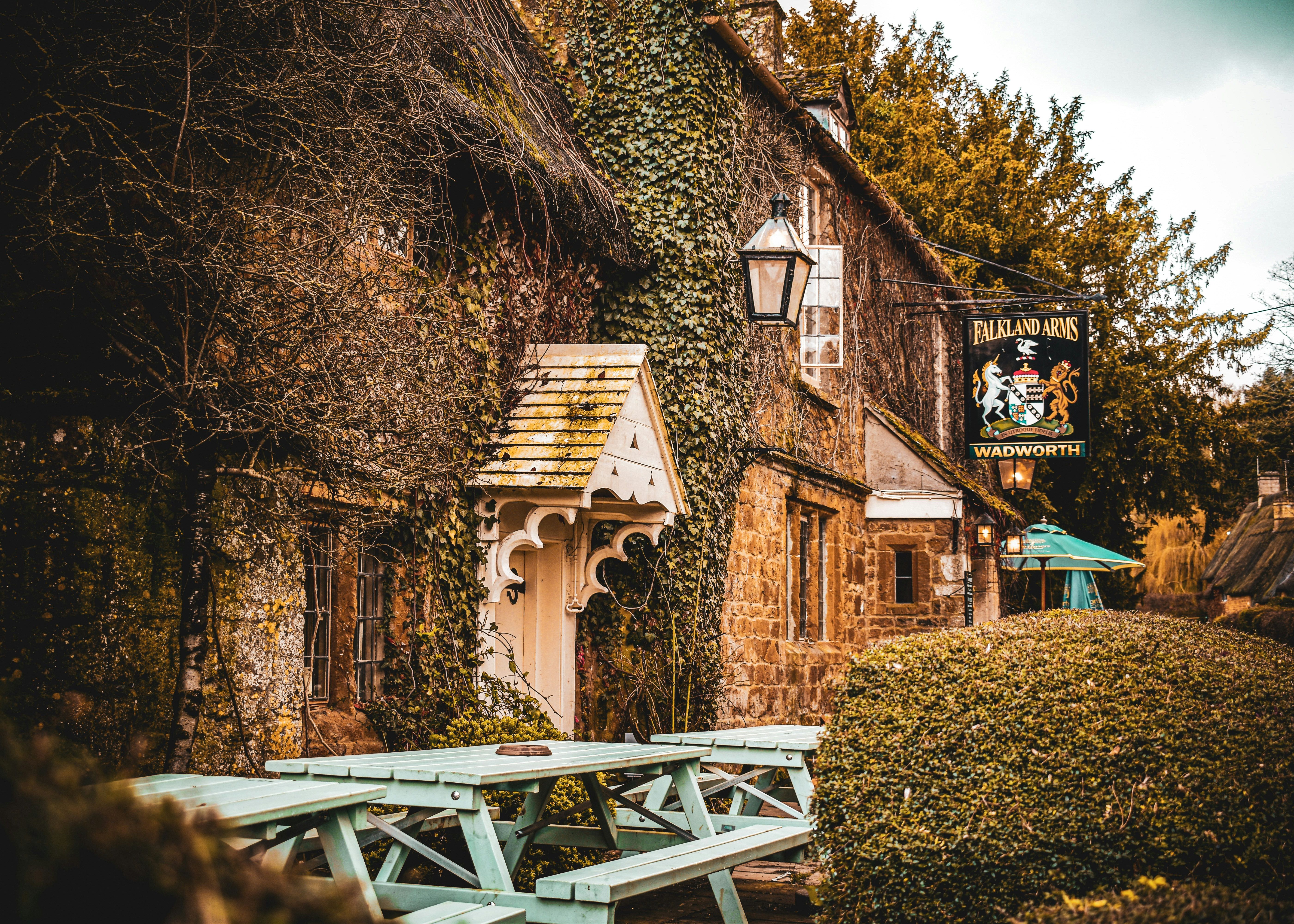 Quaint ivy-covered stone pub with outdoor benches and a Falkland Arms sign