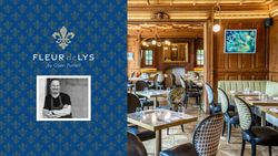 Fleur de Lys by Glynn Purnell restaurant interior with wooden panels, tables set for dining, and a blue patterned banner featuring the chef.