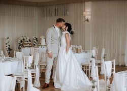 Bride and groom sharing a kiss in an elegantly decorated wedding reception venue.