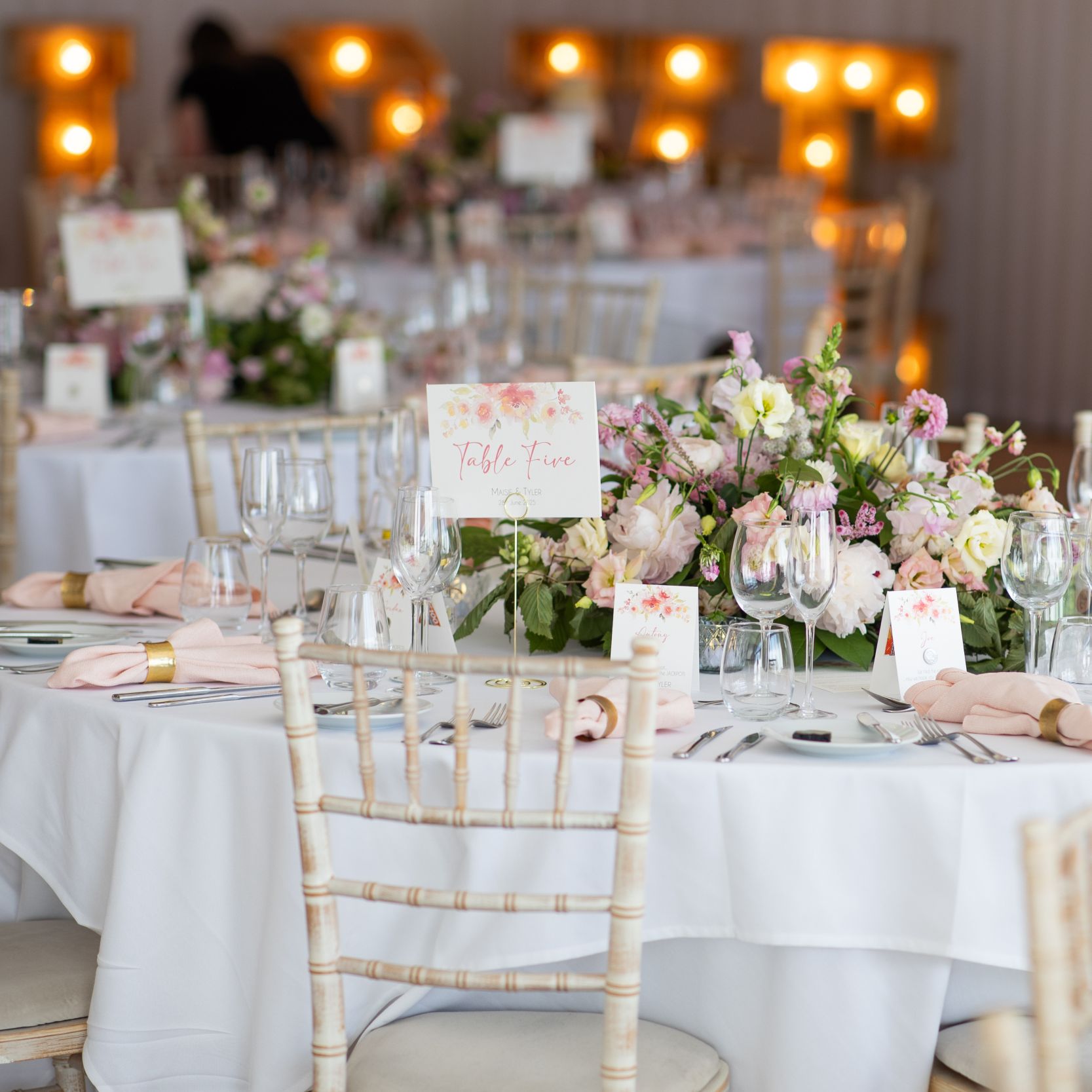 Elegant wedding reception table with floral centerpiece, place settings, and table number card