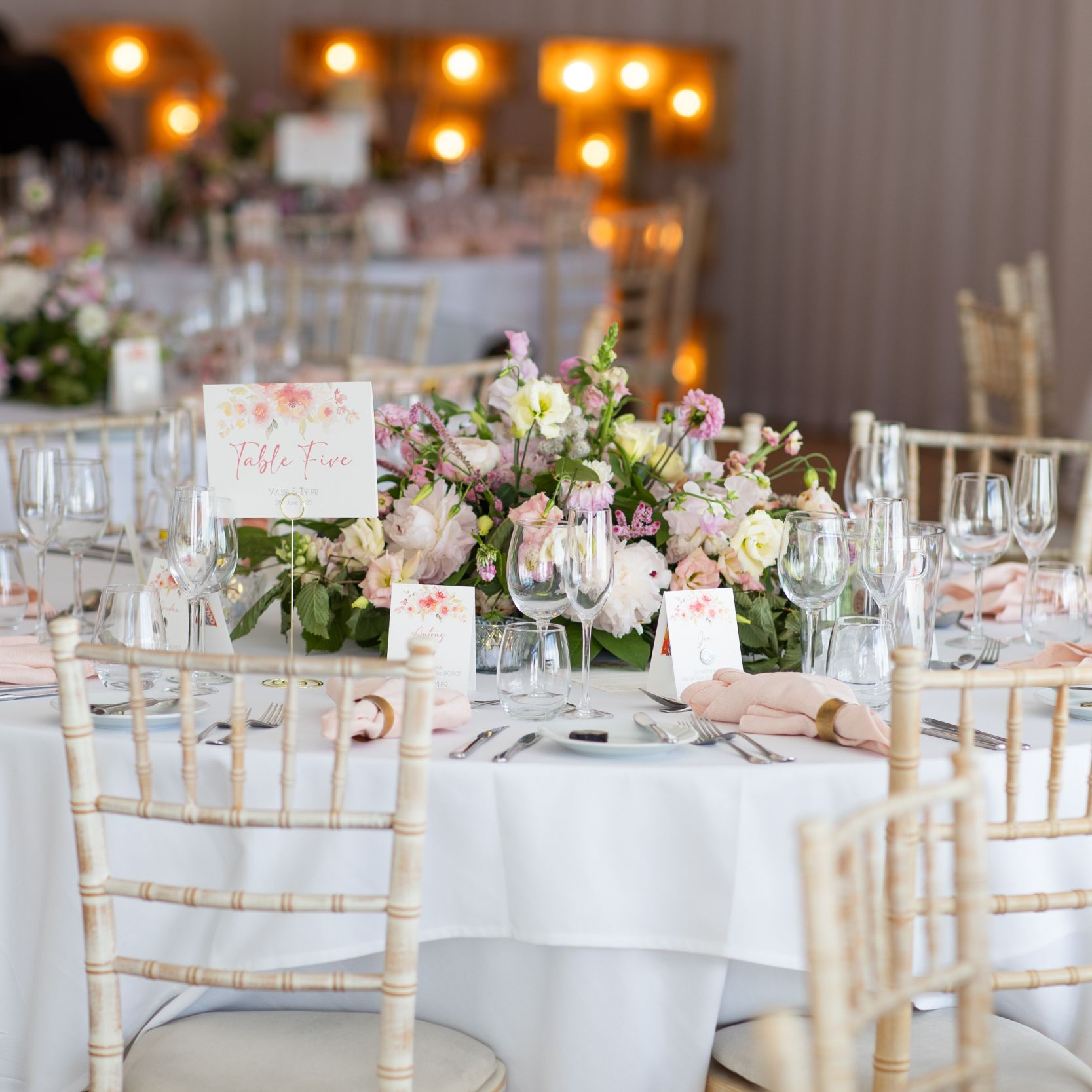 Elegant wedding reception table with floral centerpiece, place settings, and table number card