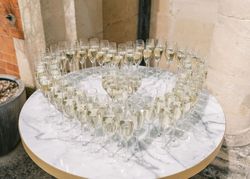 Champagne glasses arranged in a heart shape on a marble table